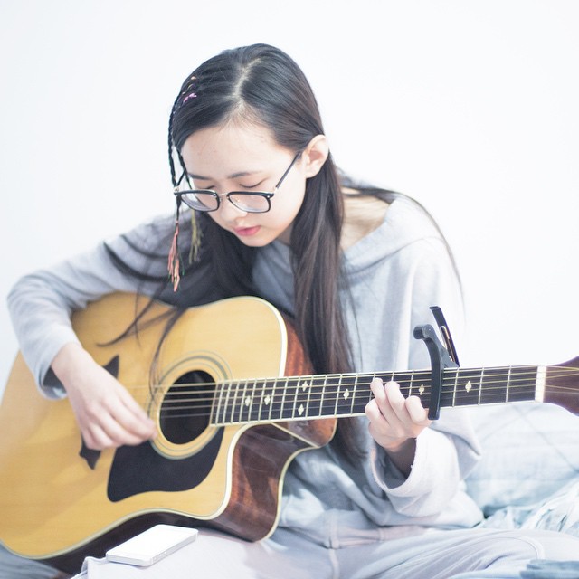 Girl playing the guitar and doing ear training